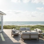 A stunning, sun-drenched coastal vacation home with a pristine white exterior, sparkling windows, and a clean wooden deck overlooking the ocean. Location is Martha's Vineyard Island