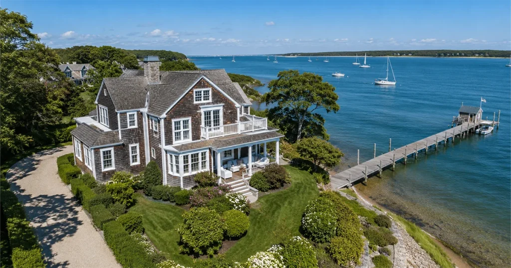 Clean cedar-shingled waterfront home on Martha's Vineyard with dock and sailboats on Vineyard Sound