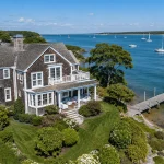 Clean cedar-shingled waterfront home on Martha's Vineyard with dock and sailboats on Vineyard Sound